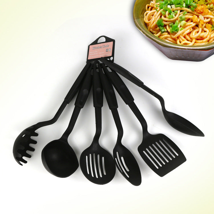 Zamora Mart kitchen set with pots, pans, utensils, and cutting board arranged on a countertop for cooking preparation.