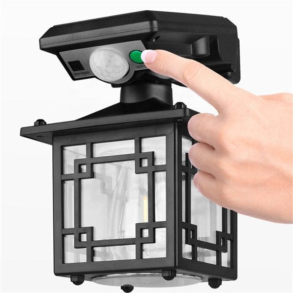 ZAMORA MART outdoor solar sensor light mounted on wall, glowing in night, with motion sensor and solar panel visible.